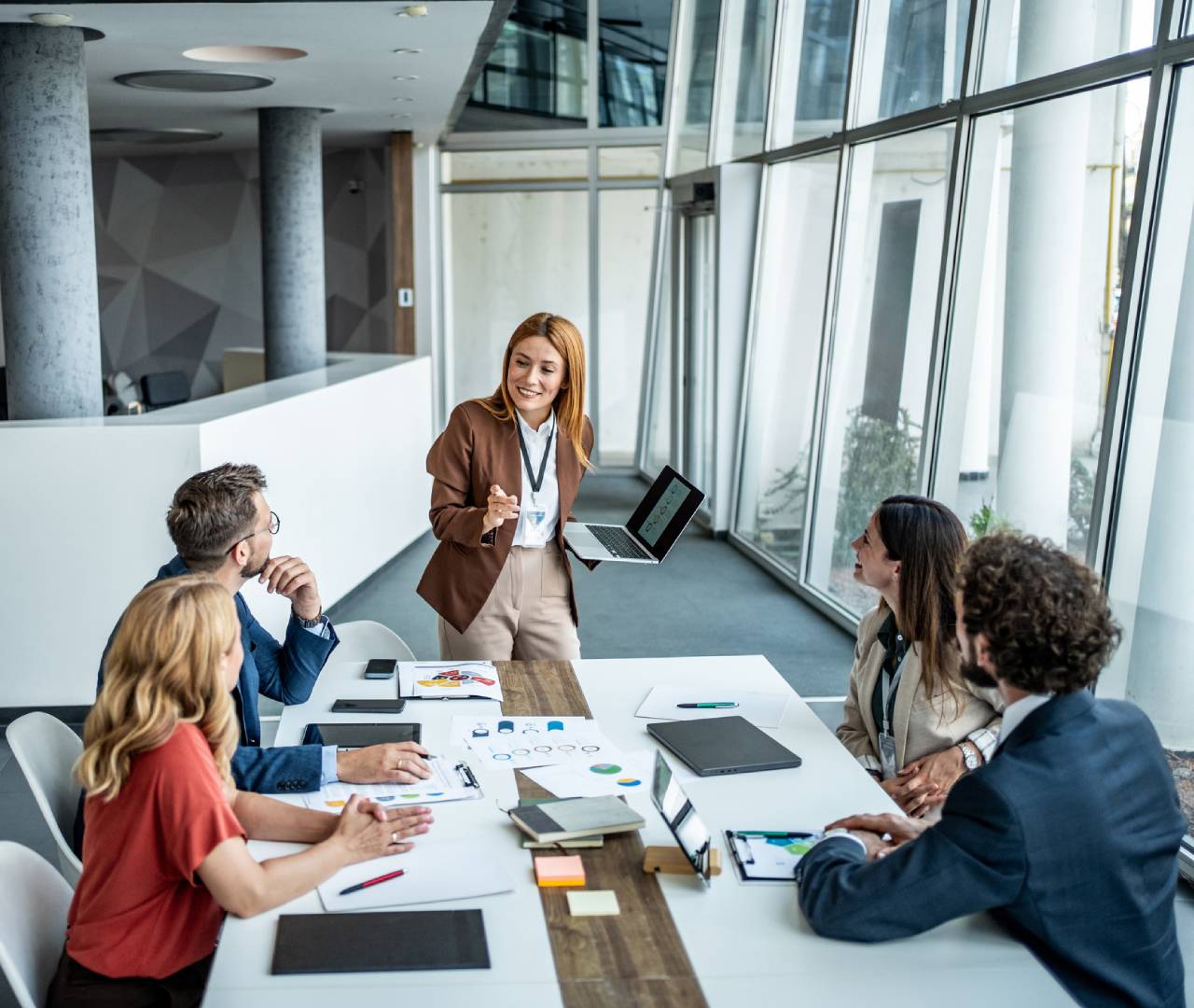 Businesswoman presenting ideas to colleagues in a modern office.